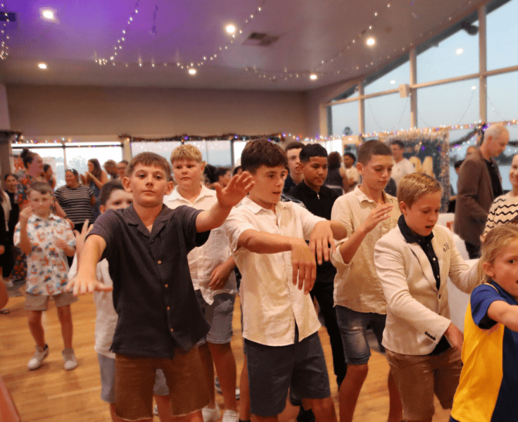 Year 6 students dancingin the hall at their graduation ceremony.